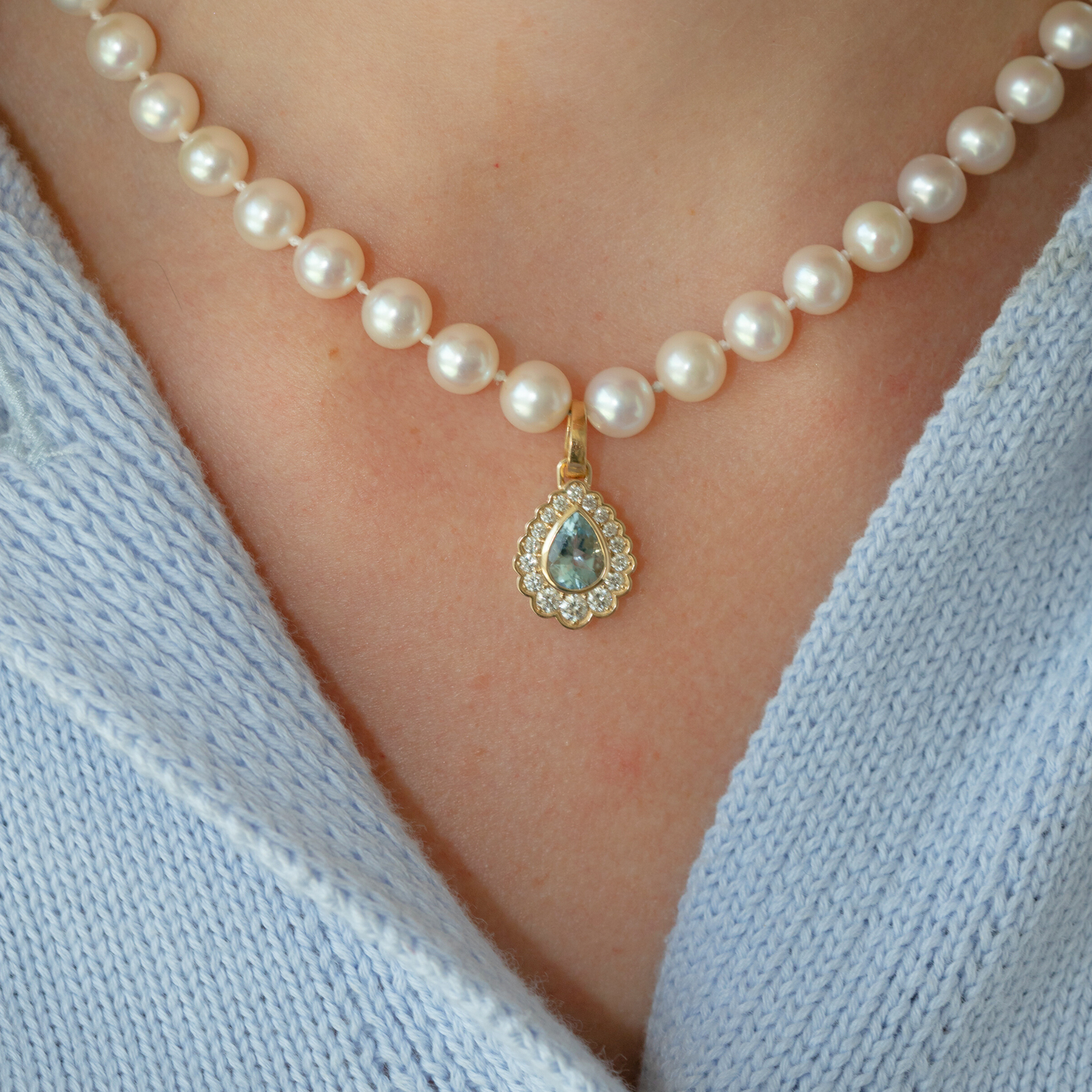 Pearl necklace with a gold teardrop pendant on pearl necklace