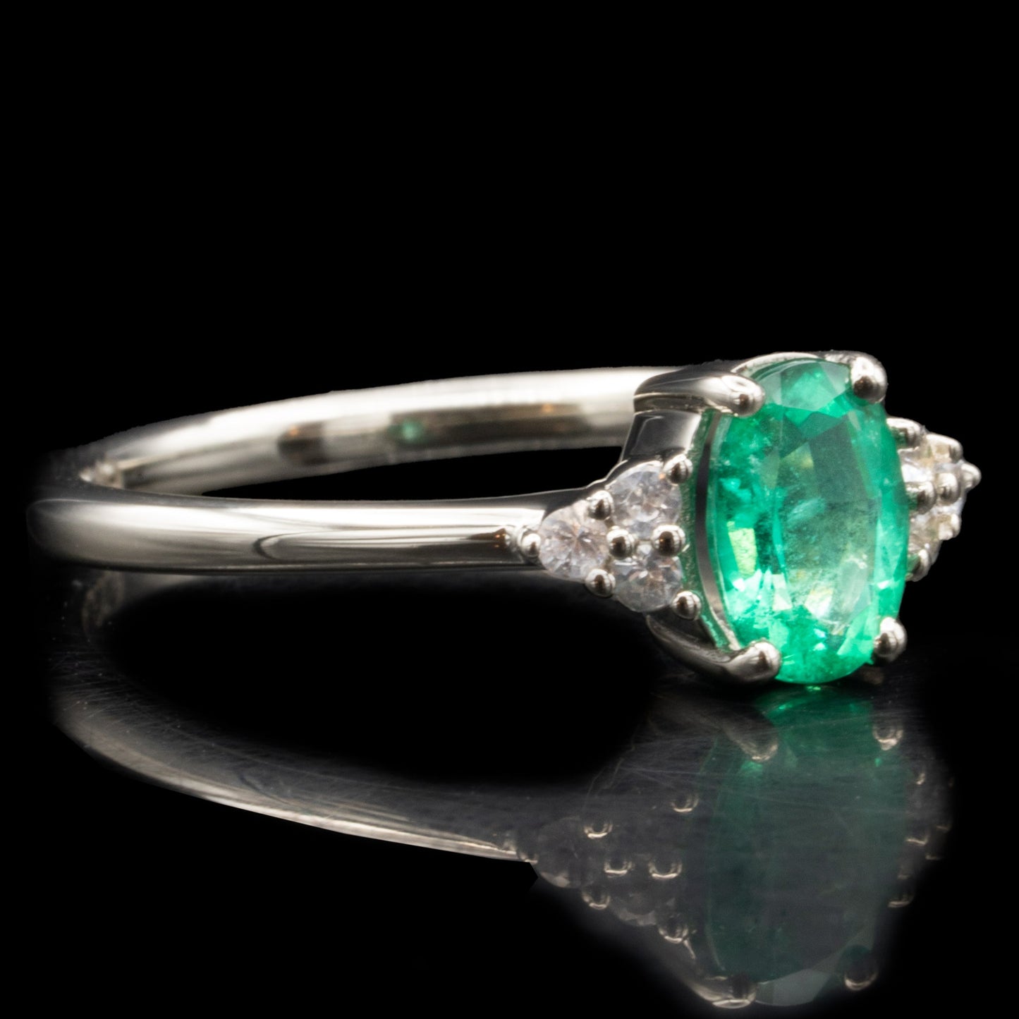 oval cut emerald engagement ring with side stones