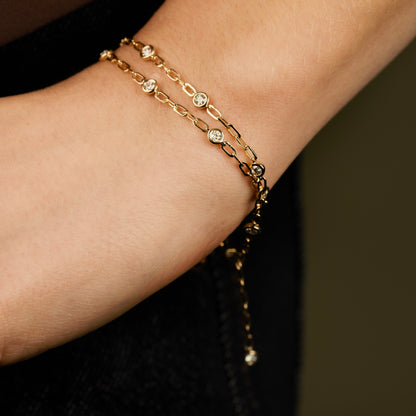 diamond bezel bracelet for women on a 14k yellow paperclip chain.