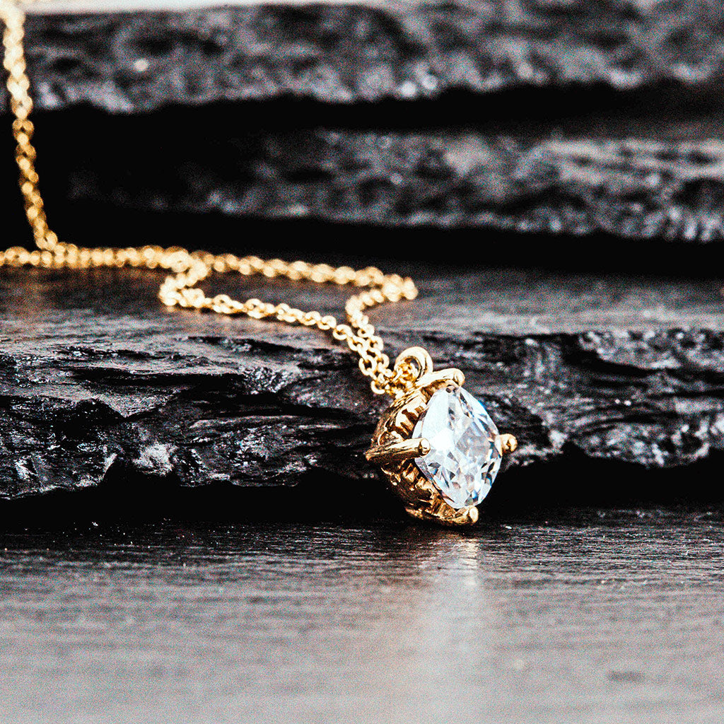 a bezel set diamond in a gold necklace