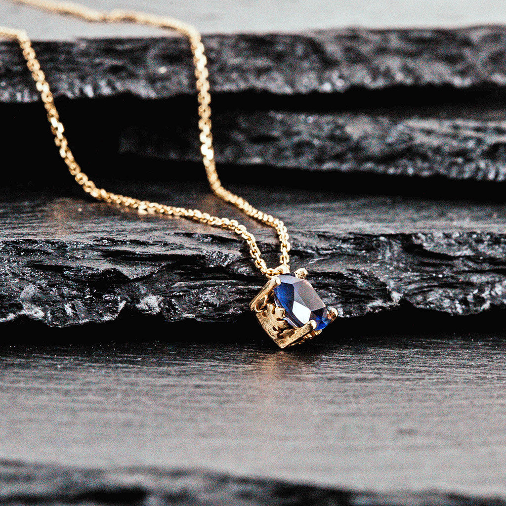 A pendent in yellow gold with an iolite cushion cut stone